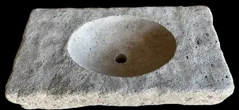 Antique limestone sink featuring a hand-carved basin and rough natural edges