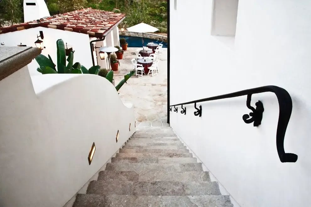 Antique Corsica Limestone, Mediterranean style outdoor stone staircase with white stucco walls and wrought iron handrail