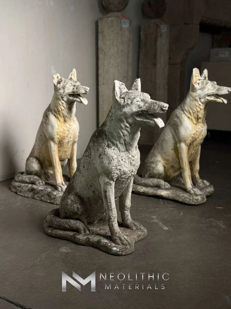 Miscellaneous FN101-05 to FN101-07.14x24x30 indoor studio snapshot showcasing three classical seated wolf hound dog sculptures with alert expressions, detailed fur textures, and a heavily weathered off-white and grey stone finish arranged on a polished concrete floor.
