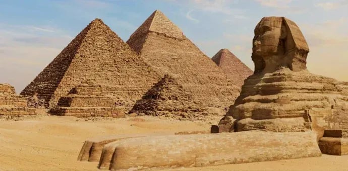 Great Sphinx of Giza and limestone Egyptian pyramids in the desert landscape